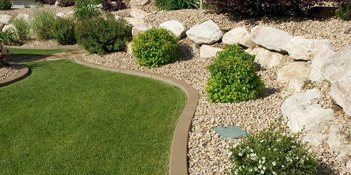 Landscaped yard with decorative rock, lawn and shrubs